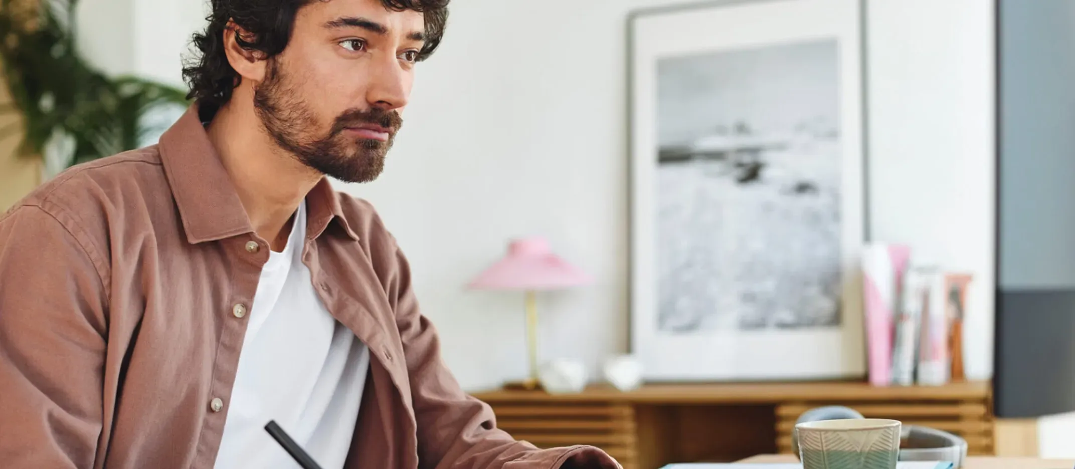 Persona escribiendo en libreta frente a computadora y taza en escritorio, representando planificación financiera para abrir cuenta Afore como trabajador independiente.