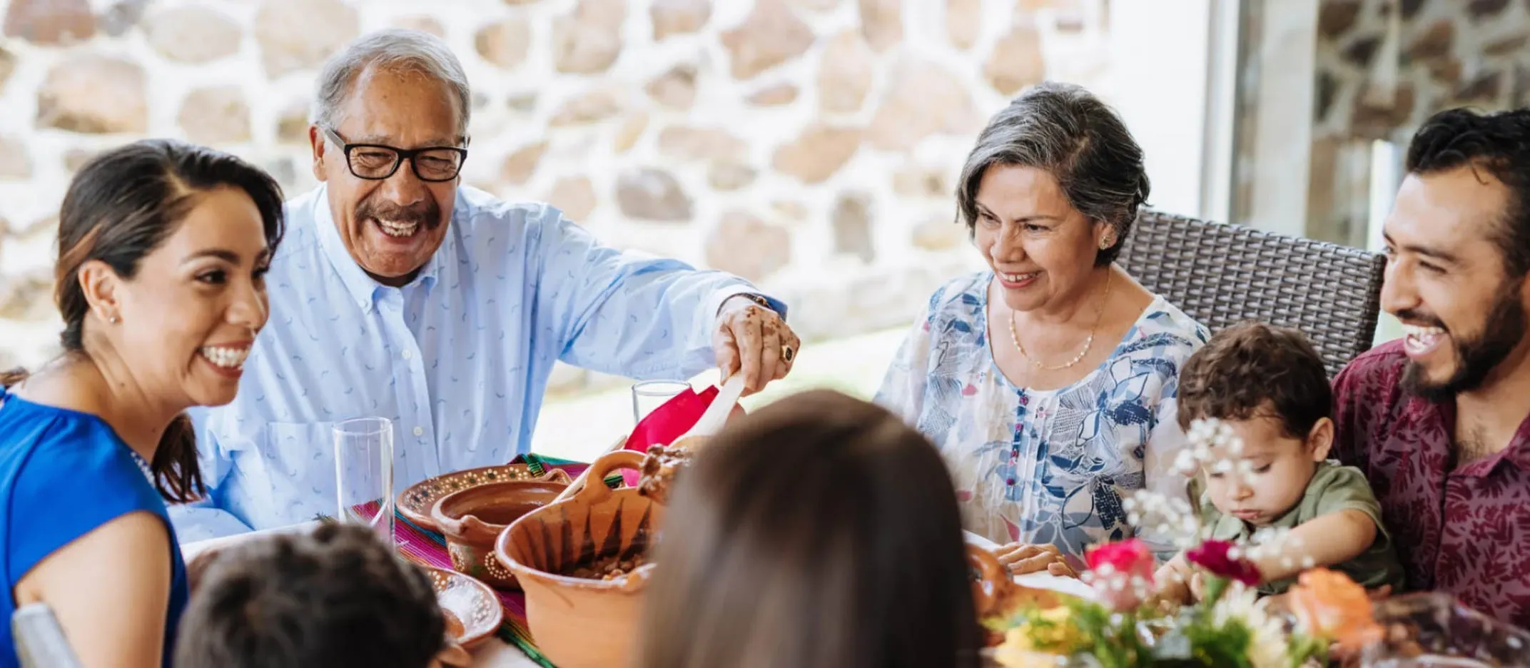 Familia reunida alrededor de una mesa compartiendo comida en un ambiente cálido y hogareño, simbolizando seguridad financiera y bienestar gracias a una buena elección de Afore.