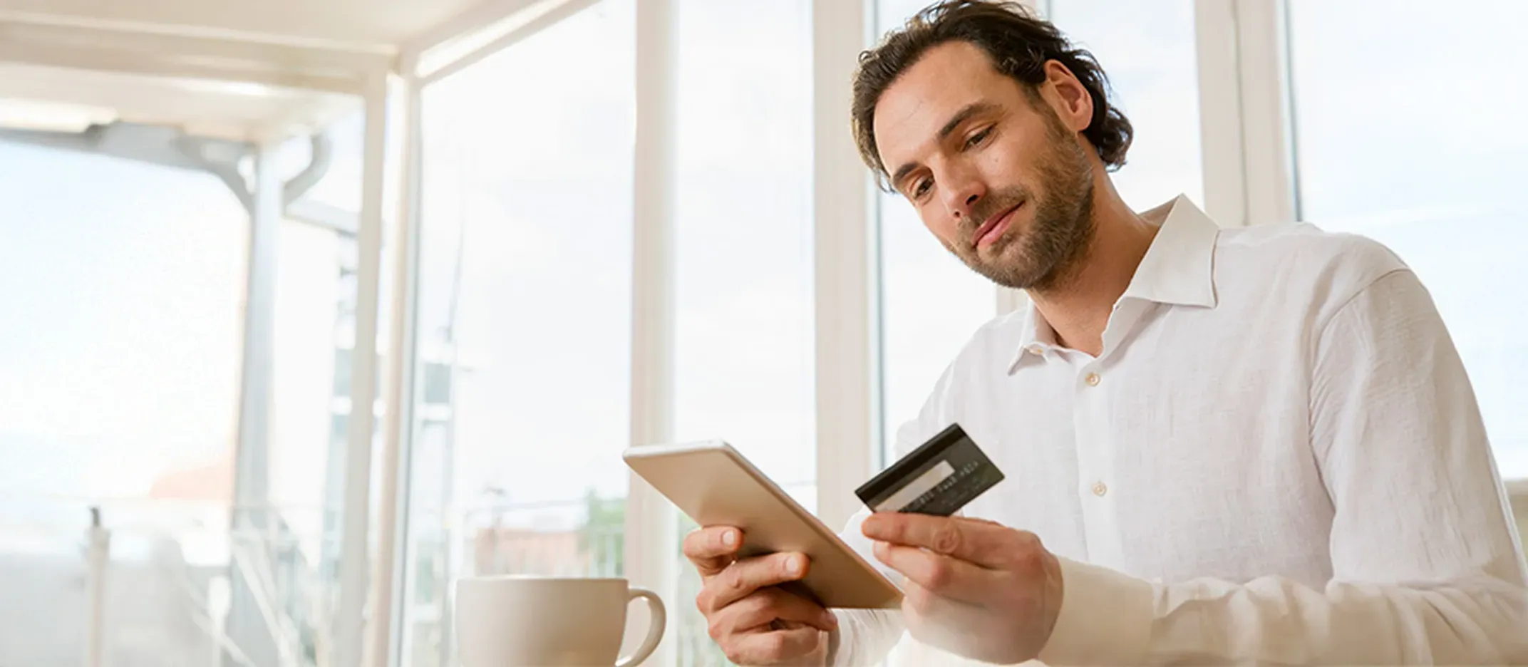 Persona realizando pago en línea con tarjeta y dispositivo móvil.