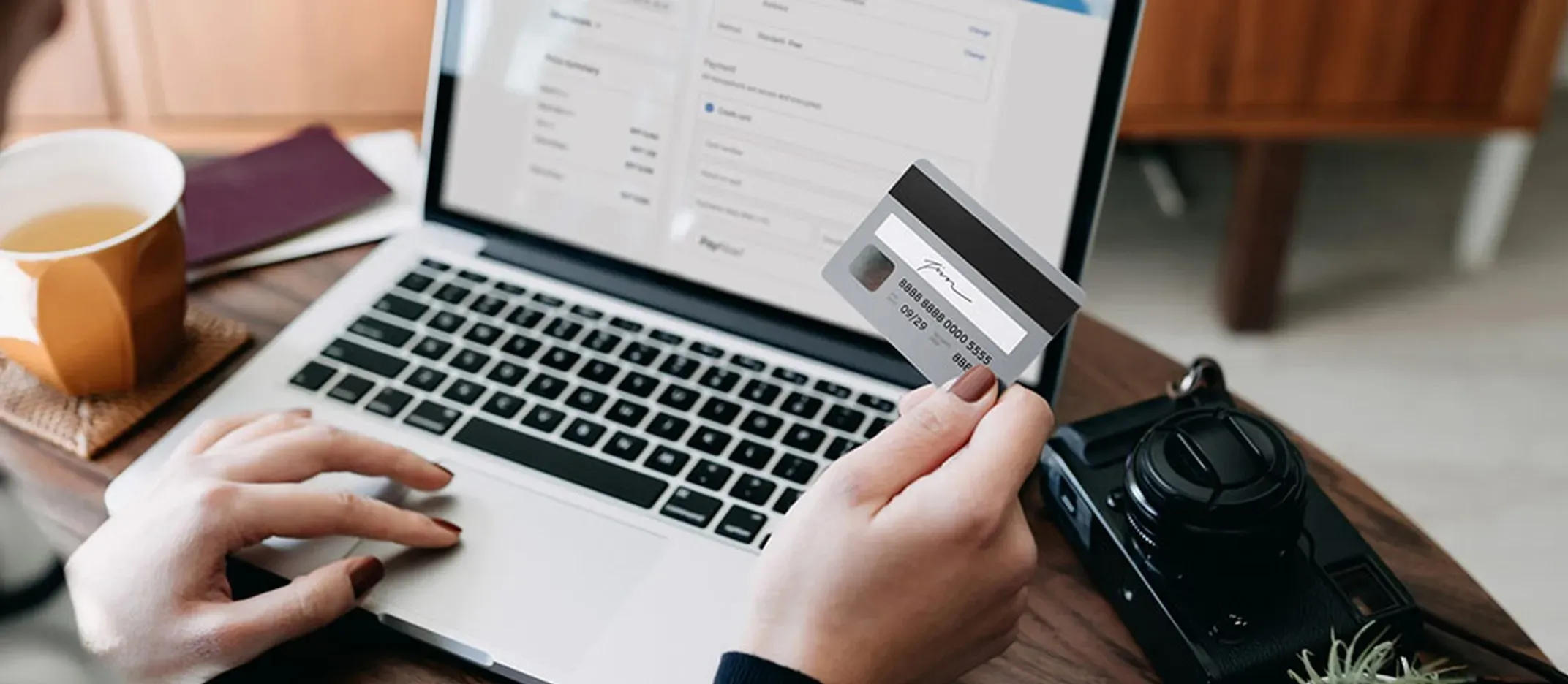 Persona gestionando portabilidad de nómina en laptop con tarjeta bancaria.