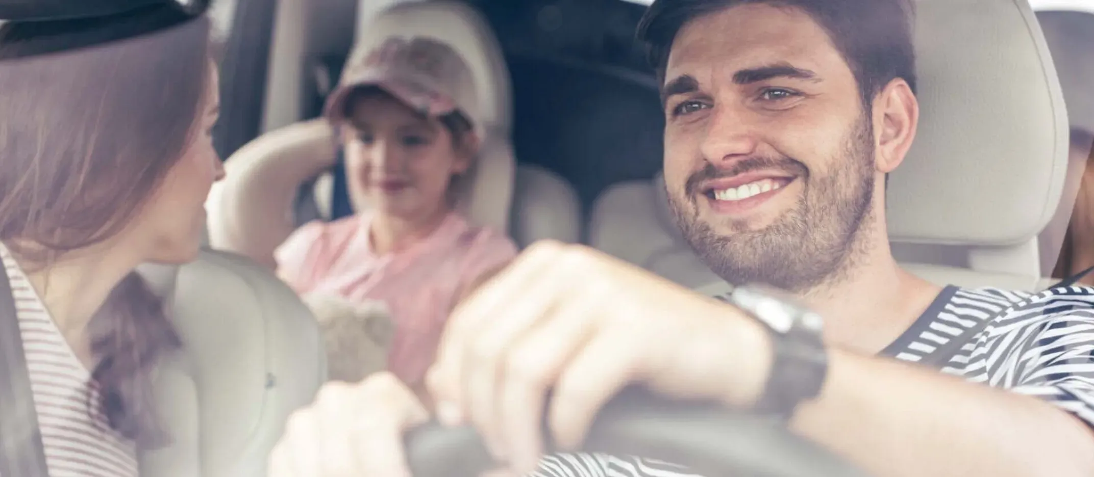 Personas viajando en automóvil, vista desde el interior del vehículo mientras circulan por carretera.