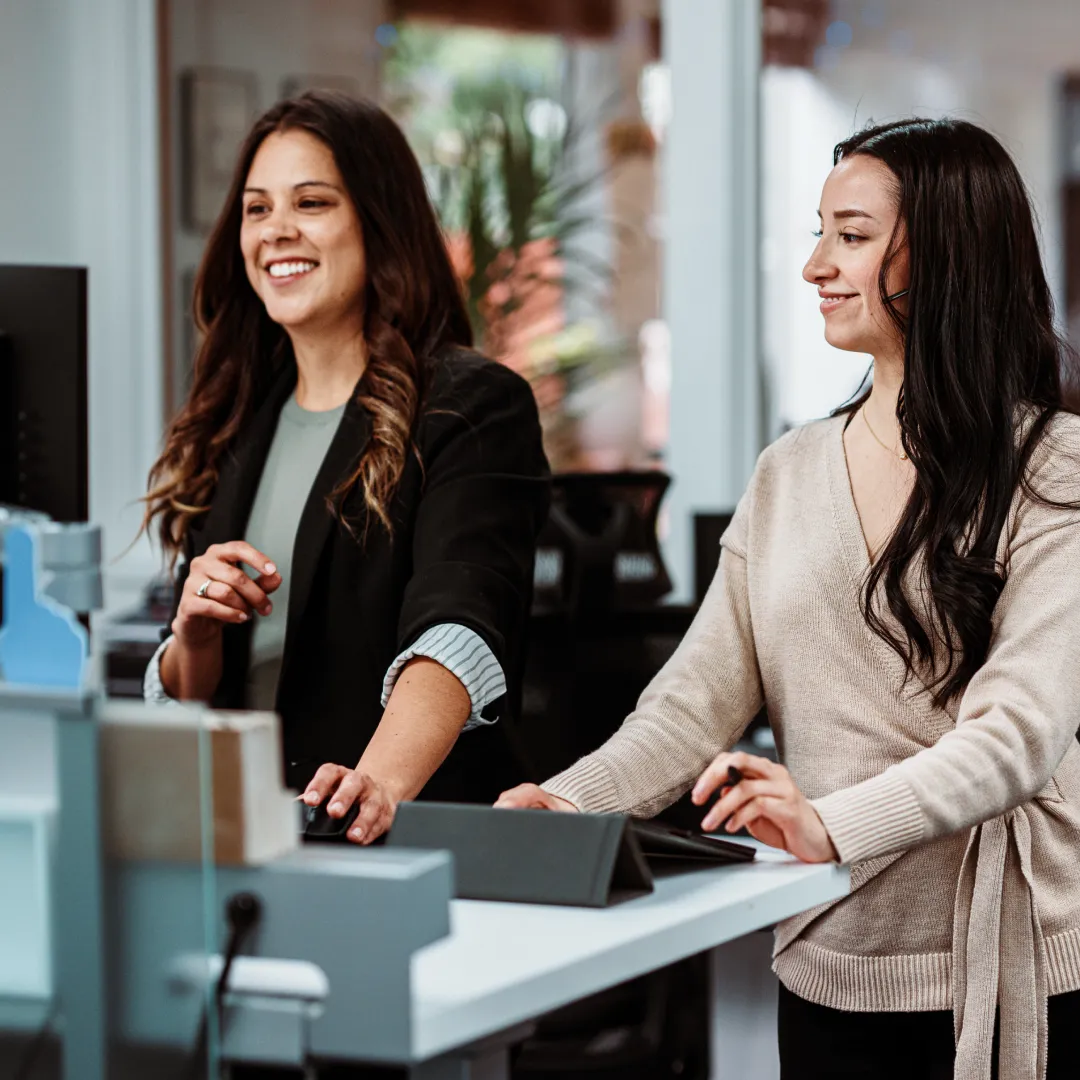 Personas utilizando equipos digitales en un entorno de oficina para gestionar procesos, información y servicios de forma colaborativa.
