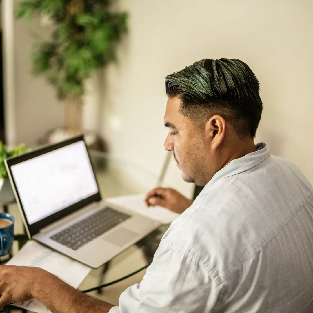 Persona utilizando una computadora portátil en un espacio de trabajo para gestionar información y realizar actividades digitales en línea.