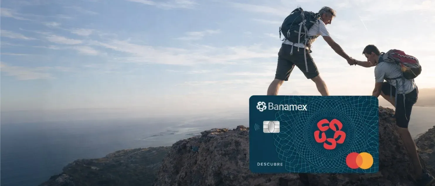 Dos personas con mochilas en la cima de una montaña junto a tarjeta Banamex Descubre.