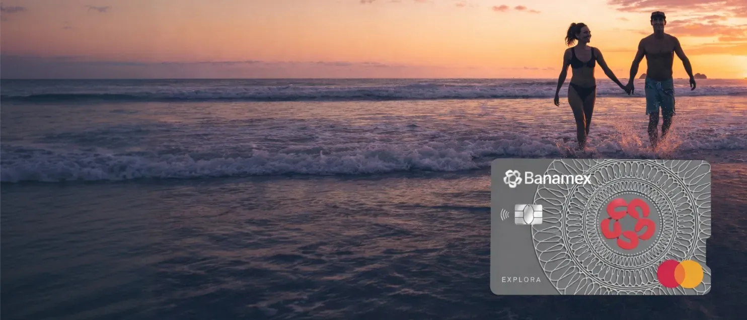 Una pareja caminando en el mar al atardecer junto a la Tarjeta de Crédito Explora Banamex.