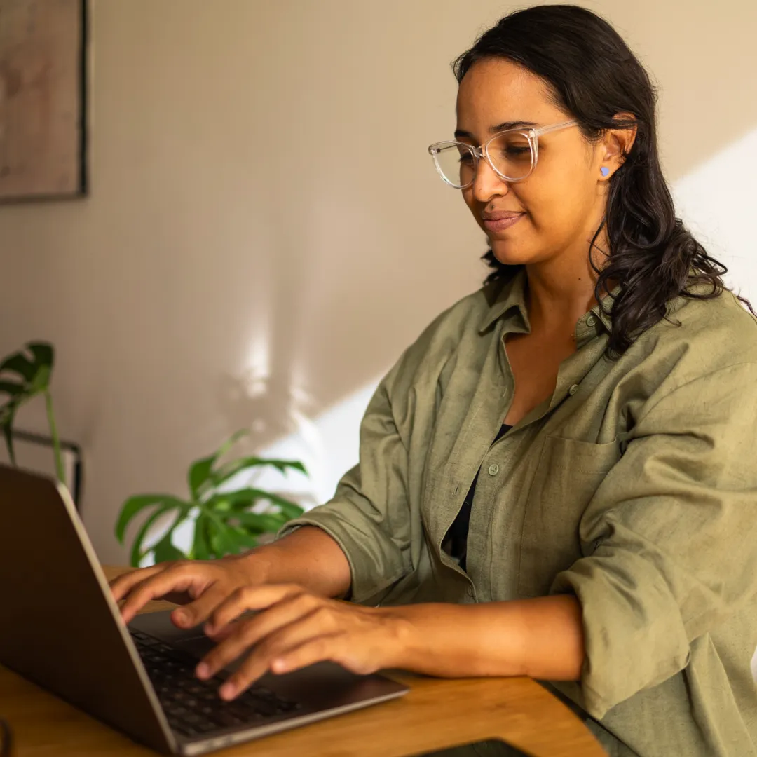 Persona utilizando una laptop desde casa para realizar actividades en línea, representando el acceso a servicios digitales, trámites y gestión financiera de forma segura con Banamex.
