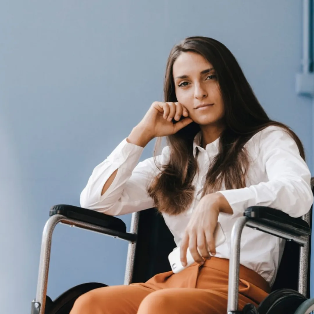 Persona usuaria de silla de ruedas sentada en un entorno profesional, representando inclusión, accesibilidad e igualdad de oportunidades para el desarrollo personal y financiero con Banamex.