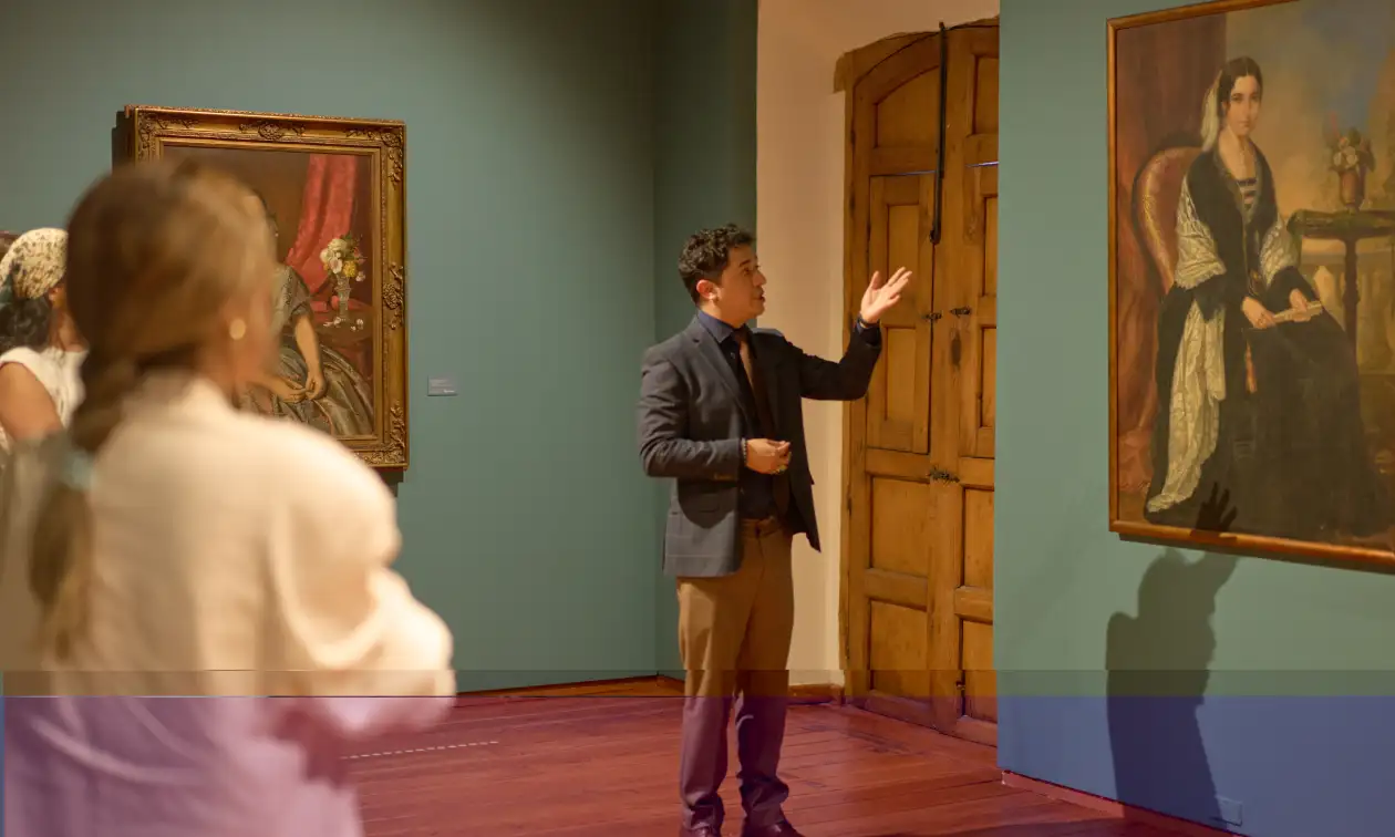 Guía presenta pinturas a visitantes en una sala de exposición de arte de Fomento Cultural Banamex