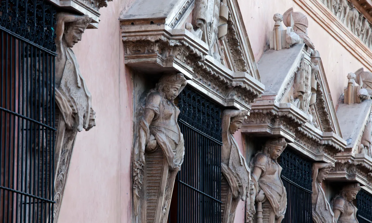 Fachada rosa con esculturas de piedra y balcones de hierro forjado de Casa Montejo, sede de Banamex en Mérida