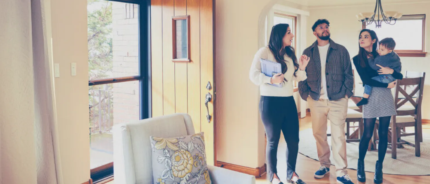 Familia recorriendo una vivienda junto a un asesor inmobiliario, durante una visita para conocer o evaluar un posible nuevo hogar.