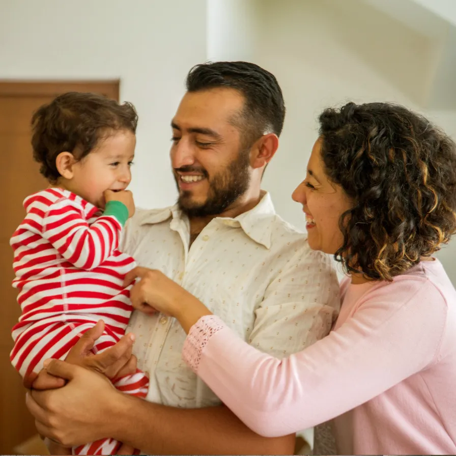 Familia disfrutando tiempo juntos en casa, compartiendo momentos cotidianos que reflejan bienestar, estabilidad y vida familiar.