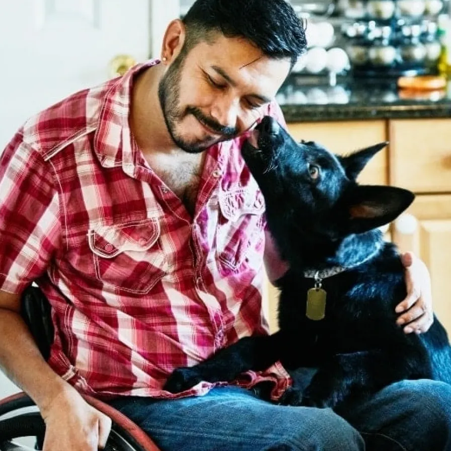 Persona compartiendo un momento de convivencia con su perro en casa, reflejando bienestar, compañía y cuidado de las mascotas.
