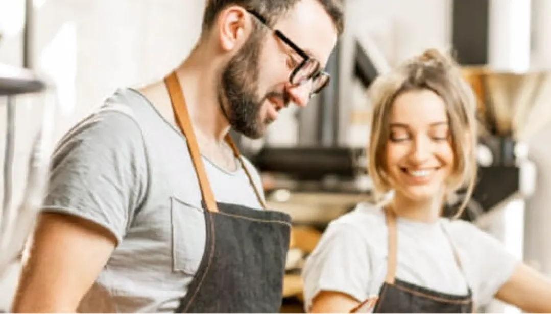 Personas utilizando equipo de trabajo en un establecimiento comercial, apoyándose en herramientas digitales para la gestión y operación de un negocio.
