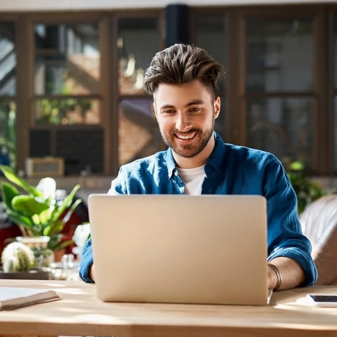Persona utilizando una computadora portátil en un espacio de trabajo moderno para gestionar trámites, finanzas o servicios digitales.