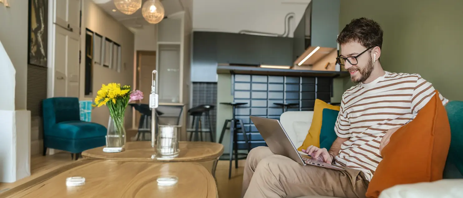 Persona trabajando en una laptop desde casa, representando la gestión de finanzas y servicios digitales de Banamex en línea.