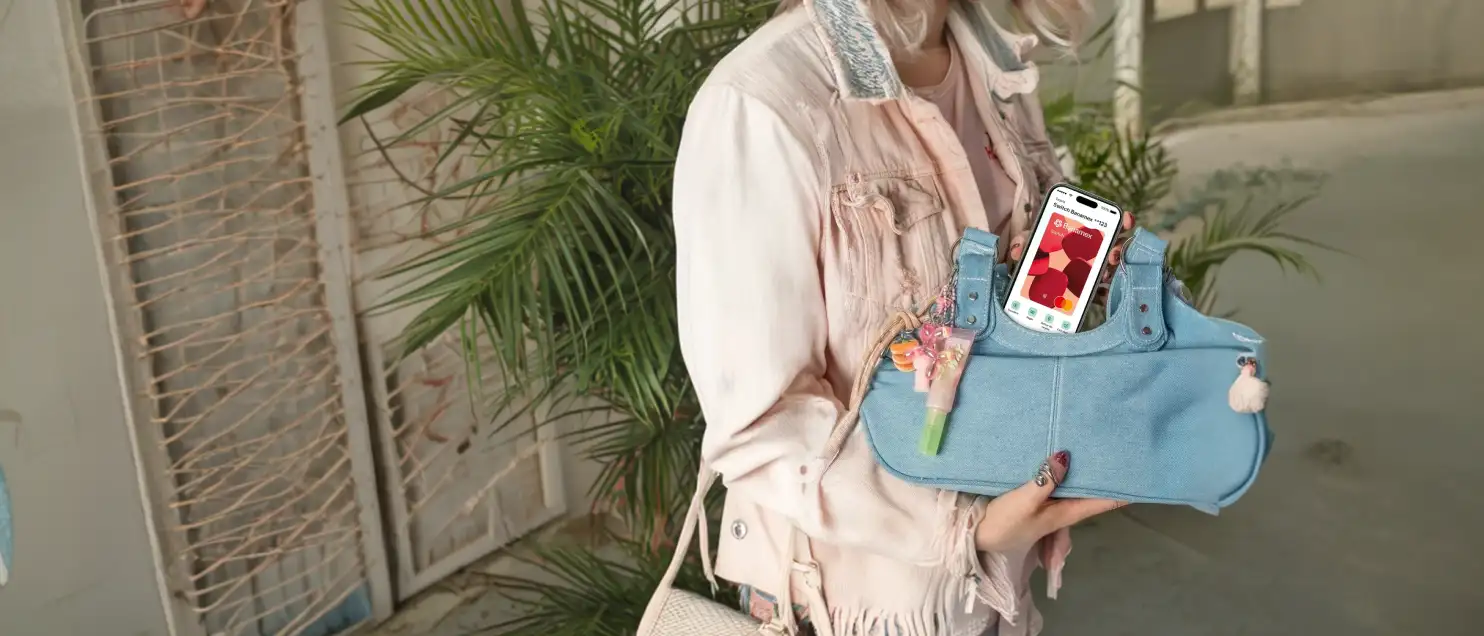 Mujer sosteniendo bolso color azul con imagen de tarjeta switch en celular