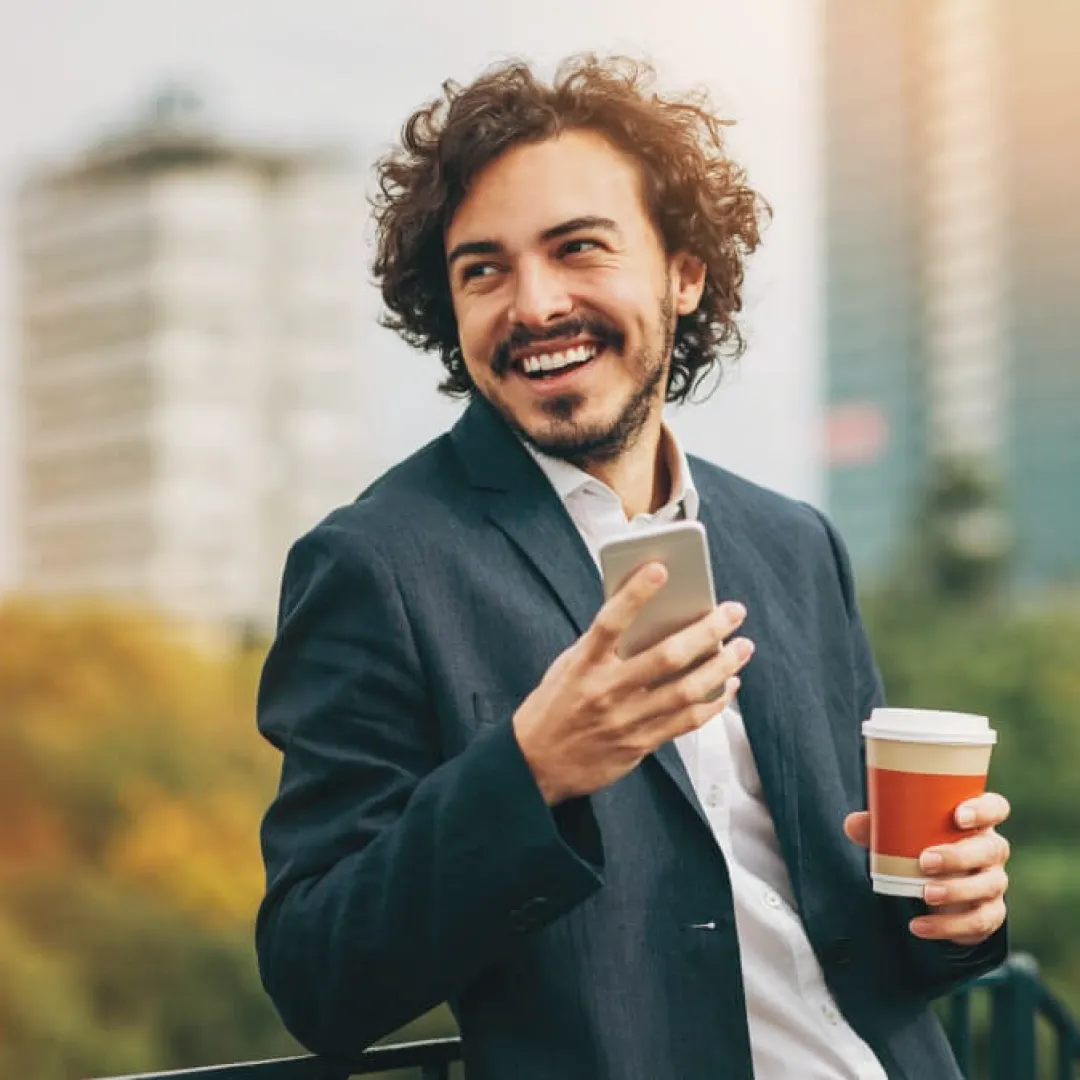 Persona consultando información desde un teléfono móvil en un entorno urbano, destacando conectividad, movilidad y servicios digitales.