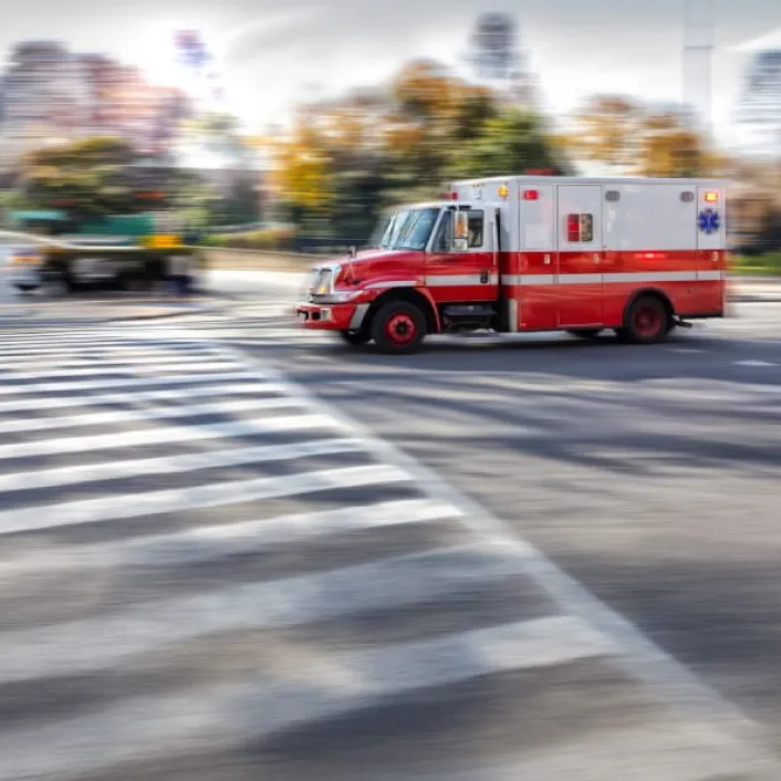 Ambulancia en circulación con luces de emergencia activadas, trasladándose por una vía urbana para brindar atención médica urgente.