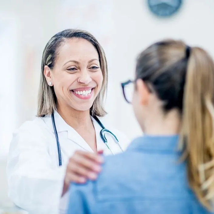 Profesional de la salud brindando orientación médica durante una consulta, revisando información clínica y resolviendo dudas de la persona atendida.