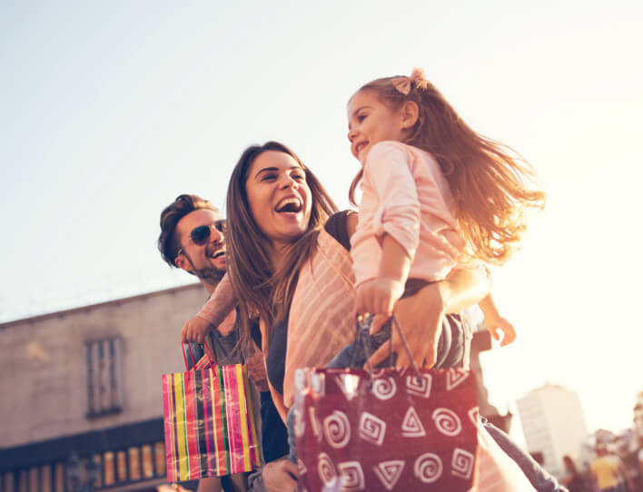 Familia disfrutando una jornada de compras juntos, compartiendo momentos de convivencia y experiencias en un entorno urbano.