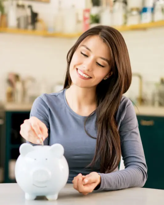 Persona ahorrando dinero en una alcancía para alcanzar metas financieras, fortalecer sus finanzas personales y planificar el futuro.