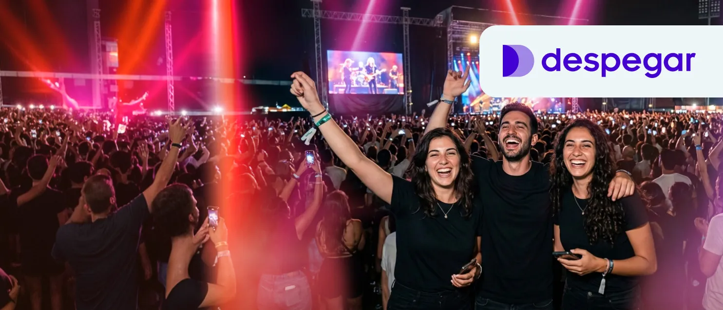 Un grupo de personas en un concierto con el escenario de fondo y el logo de Despegar.