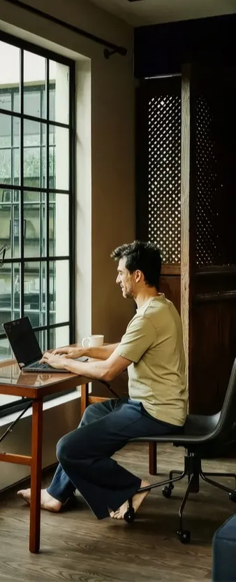 Un hombre sentado en un escritorio usando una laptop.