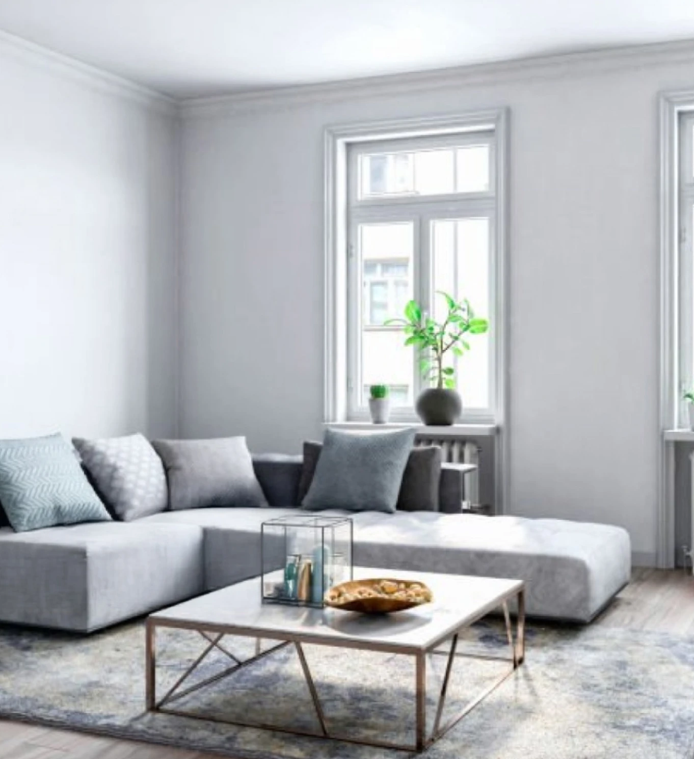 Sala de estar moderna y luminosa con sofá en tonos claros, mesa de centro y amplios ventanales que reflejan comodidad y bienestar en el hogar.