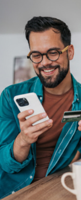 Un hombre joven revisando la App Banamex en su celular.