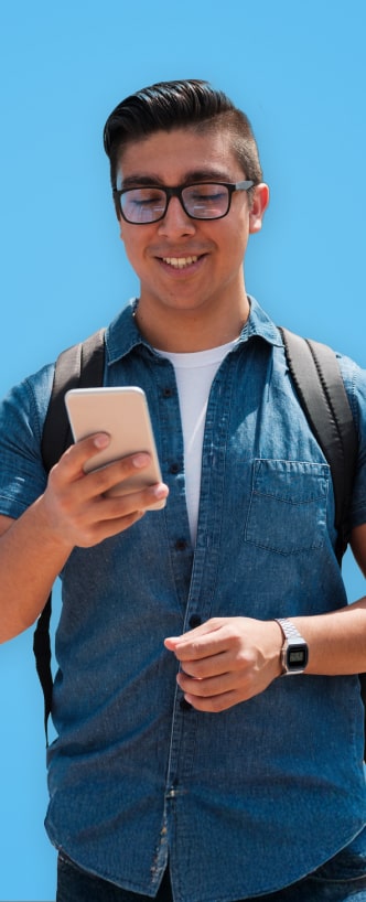 Un joven sonríendo mientras ve su celular.