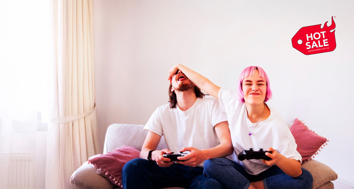 Una chica de cabello rosa tapa los ojos de su amigo mientras juegan videojuegos en un sillón; el logo de Hot Sale aparece en la imagen.