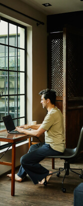 Un hombre sentado en un escritorio usando una laptop.