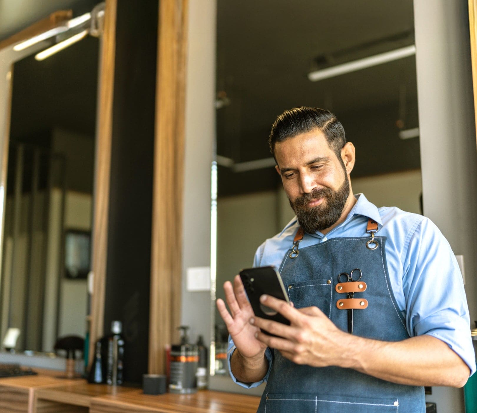 Hombre en negocio con celular.
