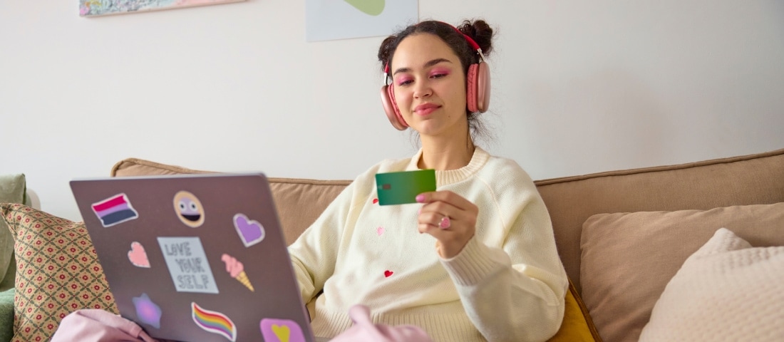 Una mujer revisando su tarjeta para comprar en línea a través de su computadora en este Buen Fin. 